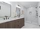 Modern bathroom featuring double vanity, a large mirror, and a spacious walk-in shower with marble tile at 1727 Lowell Blvd, Denver, CO 80204