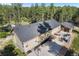 An aerial view shows the home, patio with furniture, and basketball court surrounded by evergreen trees at 11044 Conestoga Pl, Franktown, CO 80116