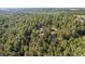 Aerial view features a home surrounded by a dense evergreen forest with a view of the home's dark roof at 11044 Conestoga Pl, Franktown, CO 80116