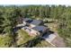 Expansive aerial shot showcasing the home's layout, garage, outdoor patio, and surrounding wooded area at 11044 Conestoga Pl, Franktown, CO 80116