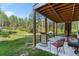 Relaxing back patio with open wooden ceiling, seating and scenic outdoor views at 11044 Conestoga Pl, Franktown, CO 80116