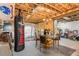 Finished basement area with exposed ceiling, gym equipment, a table, and a punching bag at 11044 Conestoga Pl, Franktown, CO 80116