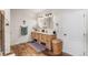 Bathroom featuring a double vanity, tiled shower, and wood-look flooring at 11044 Conestoga Pl, Franktown, CO 80116
