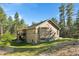 Exterior angle of home showcasing two-story deck and picturesque wooded setting at 11044 Conestoga Pl, Franktown, CO 80116