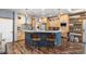 Kitchen with a breakfast bar, custom wood cabinetry, stainless steel appliances, and hardwood floors at 11044 Conestoga Pl, Franktown, CO 80116