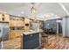 Kitchen with a breakfast bar, custom wood cabinetry, stainless steel appliances, and hardwood floors at 11044 Conestoga Pl, Franktown, CO 80116