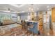 Open kitchen with breakfast bar, custom wood cabinetry, stainless steel appliances, and stylish hardwood floors at 11044 Conestoga Pl, Franktown, CO 80116