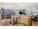 Open-concept kitchen featuring stainless steel appliances, farmhouse sink, granite countertops, and hardwood floors at 11044 Conestoga Pl, Franktown, CO 80116