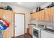 Well-equipped laundry room with modern washer and dryer units, cabinets, and a sink at 11044 Conestoga Pl, Franktown, CO 80116