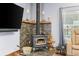 Cozy living room features a wood-burning stove with decorative stone surround and built-in shelving at 11044 Conestoga Pl, Franktown, CO 80116