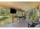 Spacious covered deck with outdoor furniture, a television, and a selection of grills at 11044 Conestoga Pl, Franktown, CO 80116