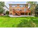 Expansive backyard with lush lawn, mature trees, and a spacious deck, perfect for outdoor activities and relaxation at 1997 Fox Haven Dr, Castle Rock, CO 80104