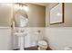 Half bathroom featuring a white sink, toilet, wainscoting, and neutral paint at 1997 Fox Haven Dr, Castle Rock, CO 80104