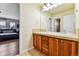 Bright bathroom with double sinks, tile floors, and a view into an adjacent bedroom at 1997 Fox Haven Dr, Castle Rock, CO 80104