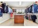 Spacious walk-in closet featuring custom shelving, ample storage, and a central dresser with countertop at 1997 Fox Haven Dr, Castle Rock, CO 80104