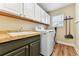 Functional laundry room features a sink, storage cabinets, and modern appliances, making laundry chores a breeze at 1997 Fox Haven Dr, Castle Rock, CO 80104