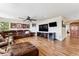 Open-concept living room featuring a leather sectional sofa, mounted TVs, and wood floors at 1997 Fox Haven Dr, Castle Rock, CO 80104