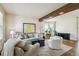 Bright living room features stylish furniture, a cozy area rug, a decorative beam, and lots of natural light at 1997 Fox Haven Dr, Castle Rock, CO 80104