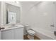 Clean bathroom featuring a vanity with sink, white tile, and a bathtub with shower at 1224 Penner Dr, Erie, CO 80026