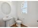 Modern powder room with pedestal sink, mirror, and window at 1224 Penner Dr, Erie, CO 80026