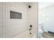 Modern bathroom featuring a tiled shower with black fixtures and a niche for toiletries at 7810 Larkwood St, Commerce City, CO 80022
