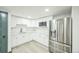 Stylish kitchen with white cabinets, stainless steel appliances, and modern herringbone backsplash at 7810 Larkwood St, Commerce City, CO 80022