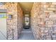 Close-up of the brick-lined entryway leading to the front door, complete with an outdoor light fixture at 6670 Club Villa Rd, Parker, CO 80134
