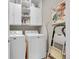 Bright laundry room with a modern white washer and dryer, and ample cabinet space at 6670 Club Villa Rd, Parker, CO 80134