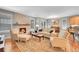 Inviting living room with a brick fireplace, neutral tones, and a view into the dining area at 6670 Club Villa Rd, Parker, CO 80134
