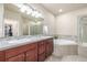 Bright bathroom with a tub, walk-in shower, and a double vanity at 19407 E Radcliff Pl, Aurora, CO 80015
