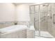 Well-lit bathroom featuring tiled floors, tub, and a glass-enclosed shower at 19407 E Radcliff Pl, Aurora, CO 80015
