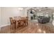 Open-concept dining room with wood floors, a chandelier, and access to the living room at 19407 E Radcliff Pl, Aurora, CO 80015