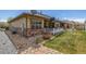A well-maintained home exterior featuring stone accents, landscaping, and a cozy patio at 19407 E Radcliff Pl, Aurora, CO 80015