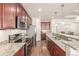 Gourmet kitchen features stainless steel appliances, granite countertops, hardwood floors, and ample counter space at 19407 E Radcliff Pl, Aurora, CO 80015