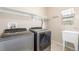 Bright laundry room with modern washer and dryer, ample storage, and a sink at 19407 E Radcliff Pl, Aurora, CO 80015
