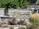 The 'Fairfield Village' community entrance sign surrounded by lush landscaping at 19407 E Radcliff Pl, Aurora, CO 80015