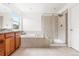 Spacious bathroom with granite counters, wood cabinets, double sinks, a shower, and a soaking tub at 12032 Triple Crown Dr, Parker, CO 80134