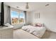 Bright bedroom featuring a modern chandelier, a large window, and comfortable looking bed at 12032 Triple Crown Dr, Parker, CO 80134