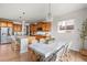 Open kitchen boasts wood cabinets, granite counters, island with bar seating, and chandelier lighting at 12032 Triple Crown Dr, Parker, CO 80134
