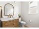 Stylish powder room with a modern vanity, arched mirror, and gold fixtures at 12032 Triple Crown Dr, Parker, CO 80134