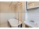 Apartment bathroom featuring white tile walls, a classic clawfoot tub with shower, and a vintage-style sink at 215 E 11Th Ave # B9, Denver, CO 80203