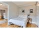 Apartment bedroom featuring neutral walls, hardwood floors, and a comfortable bed with soft, white linens at 215 E 11Th Ave # B9, Denver, CO 80203