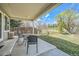 Covered back patio features stylish furniture and a view of the green backyard at 10707 W Cooper Dr, Littleton, CO 80127