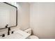 Updated half bathroom includes black hardware, modern mirror and white vanity with white countertop at 10707 W Cooper Dr, Littleton, CO 80127