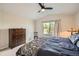 Comfortable bedroom featuring a large window, dresser and a ceiling fan for climate control at 10707 W Cooper Dr, Littleton, CO 80127