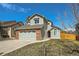 Two-story home with a brick garage, neutral siding, and a well-manicured lawn at 10707 W Cooper Dr, Littleton, CO 80127