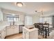 Bright kitchen featuring an island, white cabinets, and an adjacent dining space at 10707 W Cooper Dr, Littleton, CO 80127