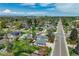 Aerial view showcasing the neighborhood, surrounding greenery, and city skyline in the distance at 4790 E Dartmouth Ave, Denver, CO 80222