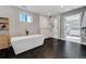 Modern bathroom featuring sleek black tile flooring, standalone tub, and a glass-enclosed shower at 4790 E Dartmouth Ave, Denver, CO 80222