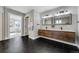 Bathroom with a modern wood vanity, dual sinks, and black hexagon tile flooring at 4790 E Dartmouth Ave, Denver, CO 80222